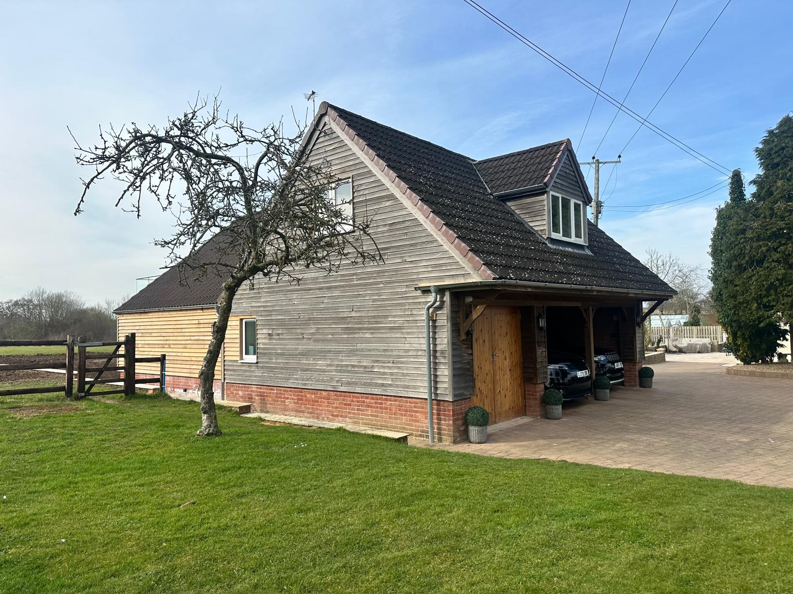 Timber-clad garage and annexe building from the garden
